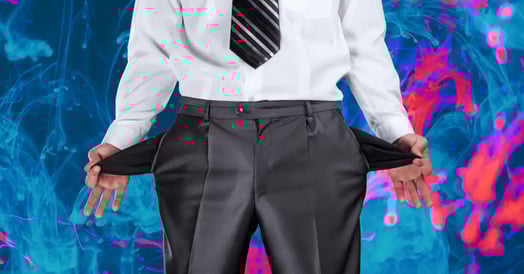 A person wearing a button-down shirt, slacks, and a tie turns out their pockets to show they are empty.